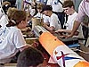 A group of students work on the components of their rocket