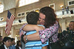 A mother celebrates her naturalization with a hug to her son. (Photo USCIS)