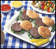Platter of grilled hamburgers and other picnic foods