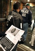Members of a team from Immigration and Customs Enforcement (ICE)attempt to gain entrance to an apartment building in search of a suspect during a sweep to capture illegal aliens with a criminal record in the Boston area.