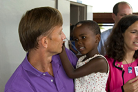 Ambassador Mark Dybul, PEPFAR Coordinator, is photographed with a child during a site visit to Reach-Out Mbuya Kinawataka Clinic on June 4, 2008.  This site visit coincided with the 2008 HIV/AIDS Implementers’ Meeting. Photo by Arne Clausen.