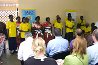 During a site visit to The AIDS Support Organization (TASO) on June 4, 2008, a group of people living with HIV/AIDS (PLWHA) perform a song about HIV treatment. Photo by Arne Clausen.