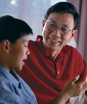 Asian father talking with son.