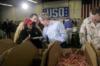 President George W. Bush and Laura Bush visit Operation USO CarePackage at Fort Belvior, Va., Friday, Dec. 10, 2004. "This is one way of saying, America appreciates your service to freedom and peace and our security," said the President in his remarks about the program that has delivered more than 480,000 care packages.