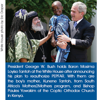 President George W. Bush holds Baron Mosima Loyiso Tantoh at the White House after announcing his plan to reauthorize PEPFAR. With them are the boy’s mother, Kunene Tantoh, from South Africa’s Mothers2Mothers program, and Bishop Paules Yowakim of the Coptic Orthodox Church in Kenya. White House photo by Eric Draper