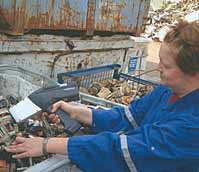 A photo of a woman using an Innov-X Systems’ handheld elemental analyzer to sort through recycled metal parts.