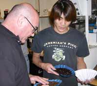 A photo of two employees at Jeremiah's Pick (JP), a gourmet coffee roaster, examine freshly roasted coffee beans.