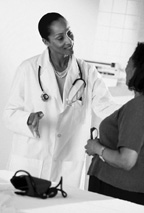 Photo of female doctor and female patient talking in a doctor's office.