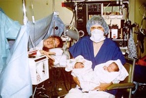 Photo of a nurse holding newborn twins
