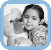 A little girl hugging a teddy bear.