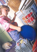 A little girl putting dishes in a dishwasher.