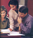 A couple with thier realtor looking over paperwork.