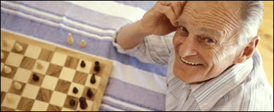 Photo: An older man playing chess.