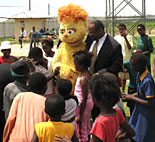 Ambassador Eric M. Bost with Kami, the HIV-positive Muppet from Takalani Sesame.