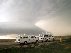 Two mobile atmospheric laboratories stop along side the road to monitor an approaching storm