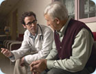 An elderly man talking to a doctor.