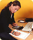 A woman using her calculator and taking notes.