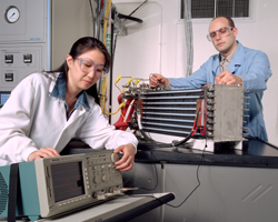 Two Argonne engineers prepare a fuel cell stack for testing.