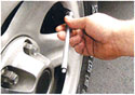 A man placing the tire gauge over the valve.