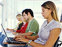 A girl using her laptop in a classroom.