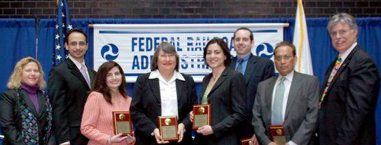 Group picture of award winners holding plaques.