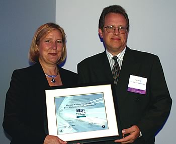 Photo showing Suzanne Rudzinski, Director, of the EPA's Transportation and Regional Programs presenting to the USPTO's Tom Hellmer an award recognizing the USPTO as one of the best workplaces for commuters.