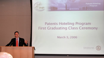 Photo showing USPTO Director Jon Dudas congratulating the Patents Hoteling Program's first graduating class.  Five-hundred patent examiners joined the hoteling program this year and began working from home, giving the USPTO more space for expansion and reducing the commute time for examiners.