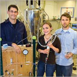 Team leader Leif Schröder (left) with Monica Smith, who holds a probe housing a phantom target, and Tyler Meldrum, holding a model of a biosensor's cryptophane cage. These members of the Alexander Pines and David Wemmer laboratories, working with team members Lana Chavez and Thomas Lowery, developed temperature-controlled molecular depolarization gates for NMR and MRI.