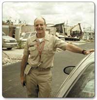 photo of David Morrissette, D.S.W., of the SAMHSA Community Support Program at the Center for Mental Health Services who was deployed to Florida after Hurricane Charley standing in front of hurricane debris