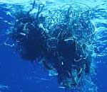 A scuba diver is shown next to a ball of tangled fishing gear.