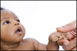 Photo: An infant holding a parent's finger.
