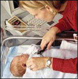 Photo: Woman checking a newborn's hearing