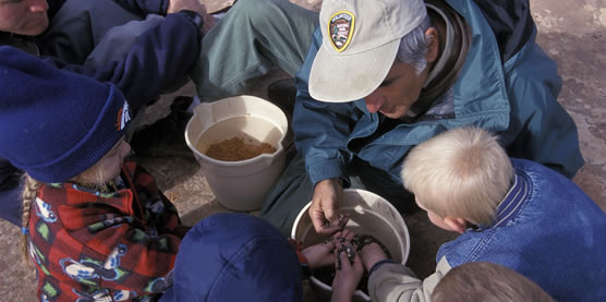 A volunteer assists children during an outdoor education program