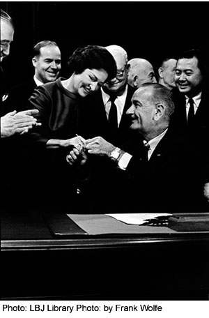 After signing the Highway Beautification Act on October 22, 1965, President Johnson hands the bill signing pen to Lady Bird in the East Room of the White House. Photo: LBJ Library Photo by Frank Wolfe.