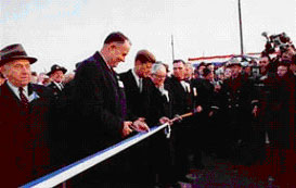 The Maryland Northeastern Expressway-Delaware Turnpike opened on November 14, 1963, with President John F. Kennedy helping to cut the ribbon before a crowd of 10,000. Left to right: Governor Elbert N. Carvel of Delaware, Kennedy, and Governor J. Millard Tawes of Maryland. The turnpike was renamed the John F. Kennedy Memorial Highway in 1965.