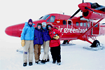 The four researchers pose in front of their air transportation to the Greenland station.