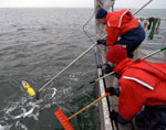Researchers on board ship retrieve the REMUS from the ocean.