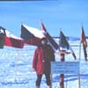 man standing outside with various flags