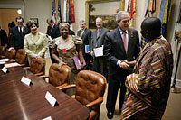 President George W. Bush welcomes Cyriaque Yapo Ako, executive director of the Reseau Ivoirien des Organisations de PVVIH in Cote d’Ivoire, Africa, to the White House World AIDS Day meeting hosted by President Bush and Laura Bush, Friday, Dec. 1, 2006. Participants included supporters of the President’s Emergency Plan for AIDS Relief (PEPFAR), which is the largest international health initiative in history dedicated to a single disease. Angelina Magaga of the Light and Courage Center Trust of Botswana, Africa, is seen center. White House photo by Eric Draper