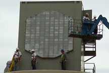 Workers install the radiating face of the phased array antenna during construction of the NWRT.