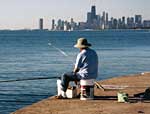 An Asian fisherman tries his luck from a pier along Chicago's Lake Michigan shore.