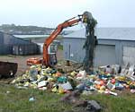 A bucket loader empties more ocean debris at this waterfront dumping site. 