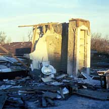 damaged home showing only the interior bathroom walls remaining