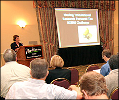 Conference speaker at the podium in front of a group of attendees