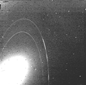 This Voyager image, FDS 11412.51, shows the three main arcs in Neptune's Adams Ring. The Liberty arc is near the lower edge of the image, followed by Equality and Fraternity above it. A fourth, fainter arc, called Courage, would be just ahead of Liberty,