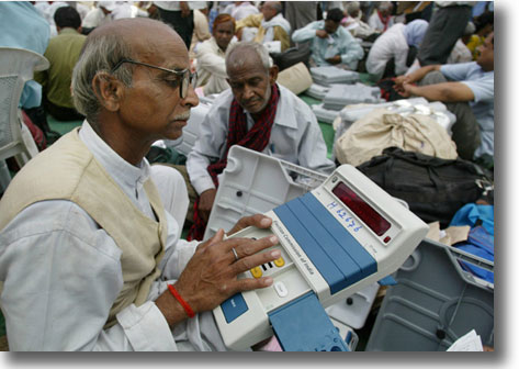 In India, a polling officer checks the electronic voting machines before the election in May 2007