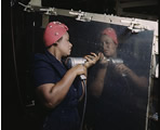 Woman operating a hand drill, working on a Vengeance dive bomber at Vultee-Nashville.  LC-DIG-fsac-1a35371
