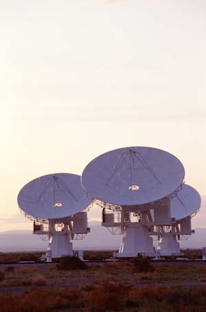 Three radio telescopes, dishes turned towards the sky.