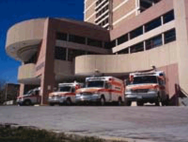 Photograph of hospital with ambulances parked outside