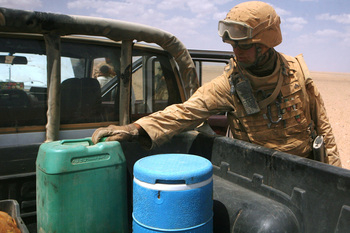 Cpl. Andrew H.Hodgkins searches a truck for illegal substances or items being smuggled across the Syrian border at a vehicle checkpoint in western Al Anbar province.